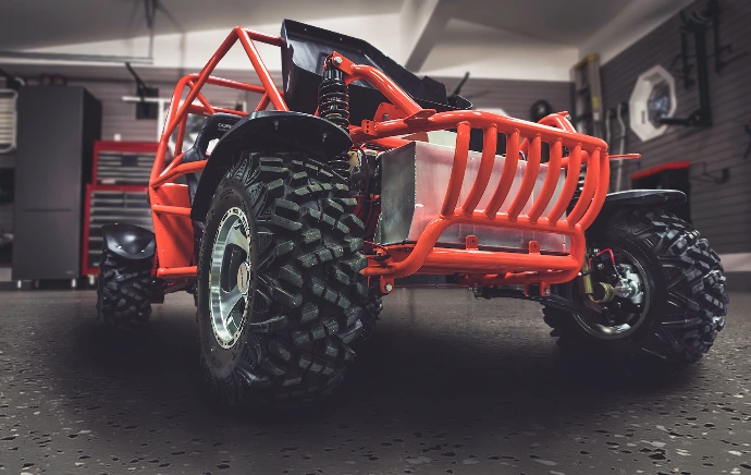An offroad buggy is parked in a garage