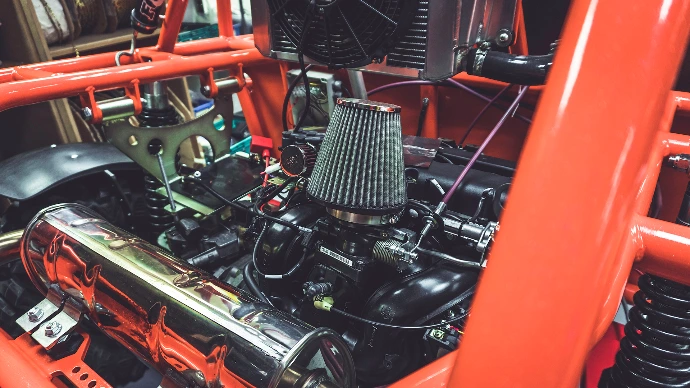The exposed engine of an offroad buggy with automotive electrical wiring and cable assemblies visible