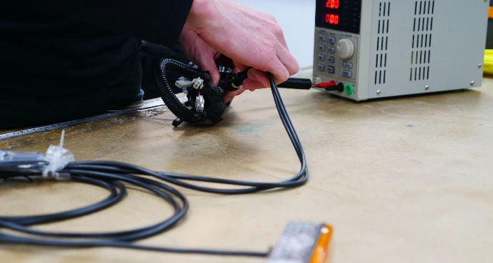 A member of testing staff testing our lighting assemblies function using a power bank