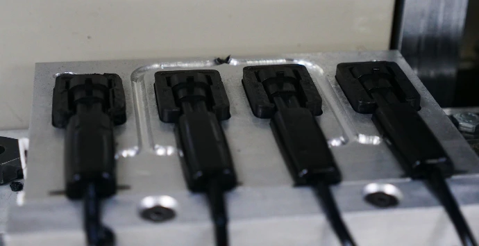 Components after overmoulding Overmoulded components in a mould. The whole connector is sealed in a polyamide moulding.